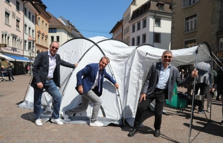 Die drei scheidenden Governors vor einem Zelt der Water Survival Box
